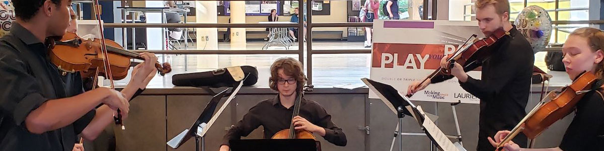Students playing in a string ensemble in the Concourse